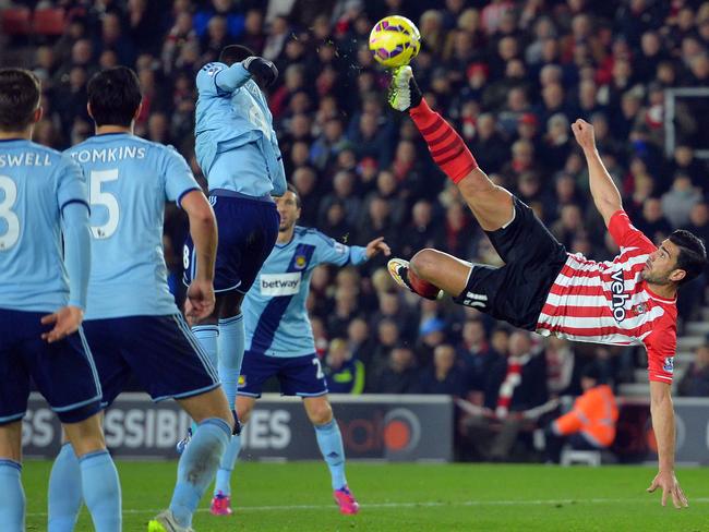 Southampton's Italian striker Graziano Pelle (R) tries an overhead kick during the English Premier League football match between Southampton and West Ham United at St Mary's Stadium in Southampton, southern England on February 11, 2015. AFP PHOTO / GLYN KIRK RESTRICTED TO EDITORIAL USE. No use with unauthorized audio, video, data, fixture lists, club/league logos or “live” services. Online in-match use limited to 45 images, no video emulation. No use in betting, games or single club/league/player publications.