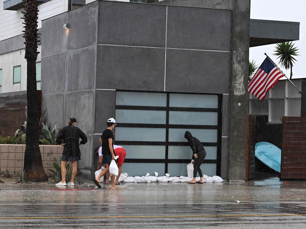 Residents place sandbags in front of a beach front home in Long Beach, California. Picture: AFP