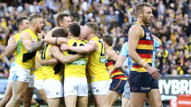 Daniel Talia walks past Tigers players celebrating a goal. Picture: SARAH REED