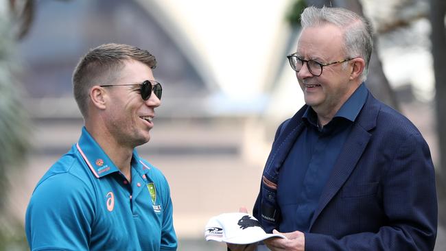 Anthony Albanese gives David Warner -- a fan of the Roosters NRL club -- a Rabbitohs hat at Kirribilli House in Sydney on Sunday. Picture: Damian Shaw