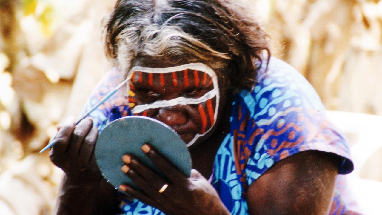 Bathurst islander Mary paints her face in preparation for performing some Tiwi dances for visitors to the islands. Picture: AAP/David S. Potts