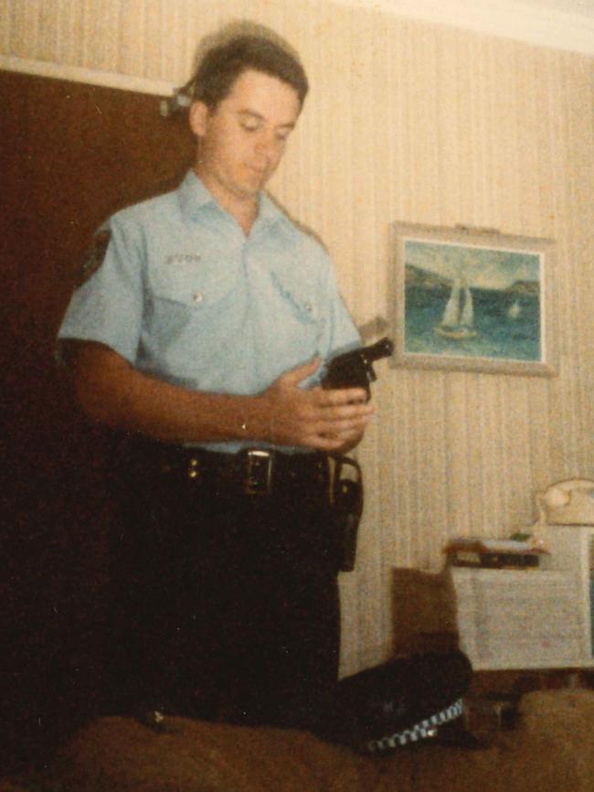 John inspecting his service revolver during his police days.