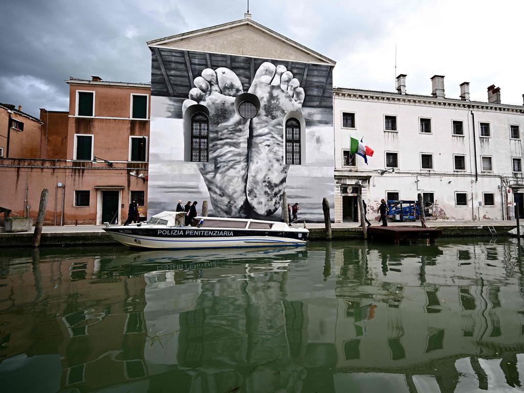 A mural of giant feet by artist Maurizio Cattelan is seen outside Giudecca Women’s Prison hosting the Holy See pavilion during the pre-opening of the 60th Venice Biennale art show, on April 18, 2024. Picture: GABRIEL Bouys/AFP