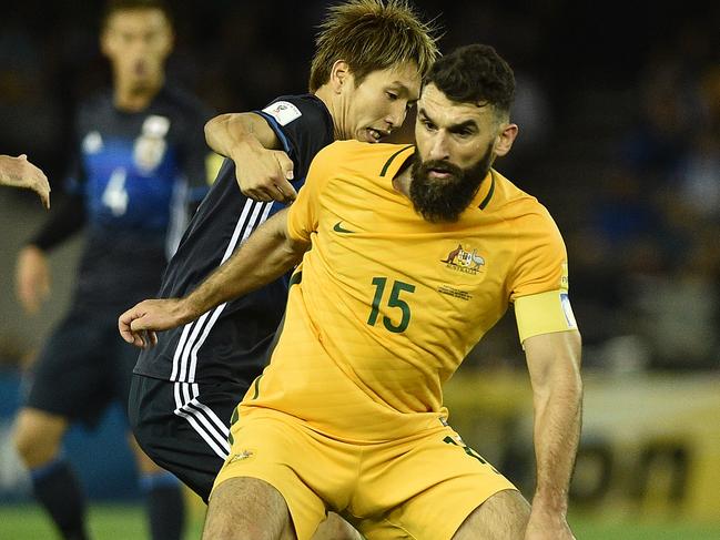 Genki Haraguchi of Japan (centre) and Mile Jedinak of Australia (right) contest during the 2018 FIFA World Cup Qualifier game between Australia and Japan at Etihad Stadium in Melbourne, Tuesday, Oct. 11, 2016. (AAP Image/Julian Smith) NO ARCHIVING, EDITORIAL USE ONLY