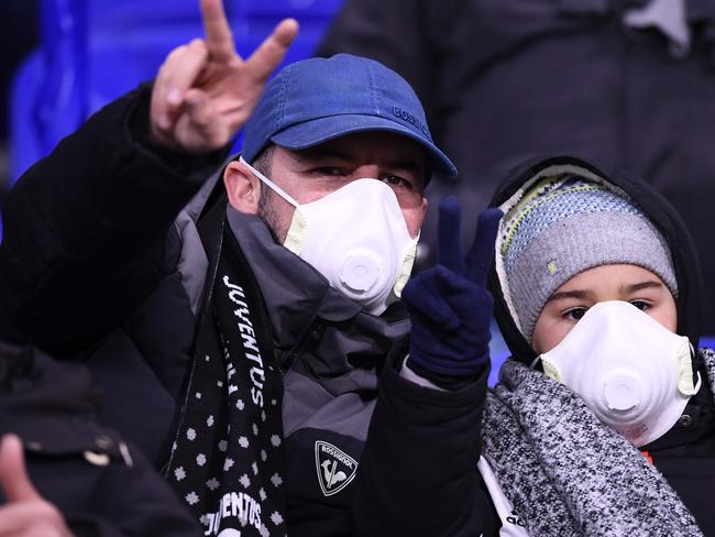 Juventus supporters wear protective face masks as a safety measure against the COVID-19 novel coronavirus at the Parc Olympique Lyonnais stadium in Decines-Charpieu, central-eastern France, on February 26, 2020, ahead of the UEFA Champions League round of 16 first-leg football match between Lyon and Juventus. (Photo by FRANCK FIFE / AFP)