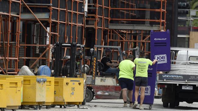 Workers remove equipment from a Probuild construction site adjacent to Caulfield Racecourse in Melbourne's southeast. Picture: NCA NewsWire / Andrew Henshaw