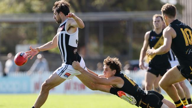 Port Adelaide’s Sam Mayes tries to get his kick away while being tackled by Tiger Brady Searle at the Bay. Picture: SANFL Image/David Mariuz.