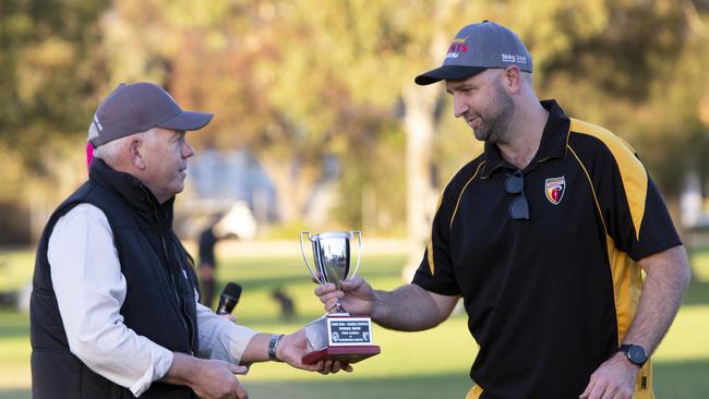 Chris Buss-Charlie Stevens Memorial Trophy Football at Goodwood Oval. Grant Stevens presents the trophy to winning Goodwood Saints Coach Ben Johnston. 25th May 2024. Picture: Brett Hartwig