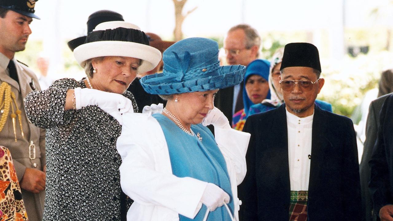 Lady Diana Farnham helps the Queen put on her coat in Brunei during one of her royal tours. Picture: Tim Graham/Photo Library via Getty Images