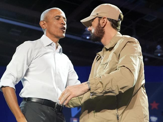 Rapper Eminem, right, greets former President Barack Obama, left, on stage at a campaign rally supporting Democratic presidential nominee Vice President Kamala Harris, Tuesday, Oct. 22, 2024, in Detroit. (AP Photo/Paul Sancya)