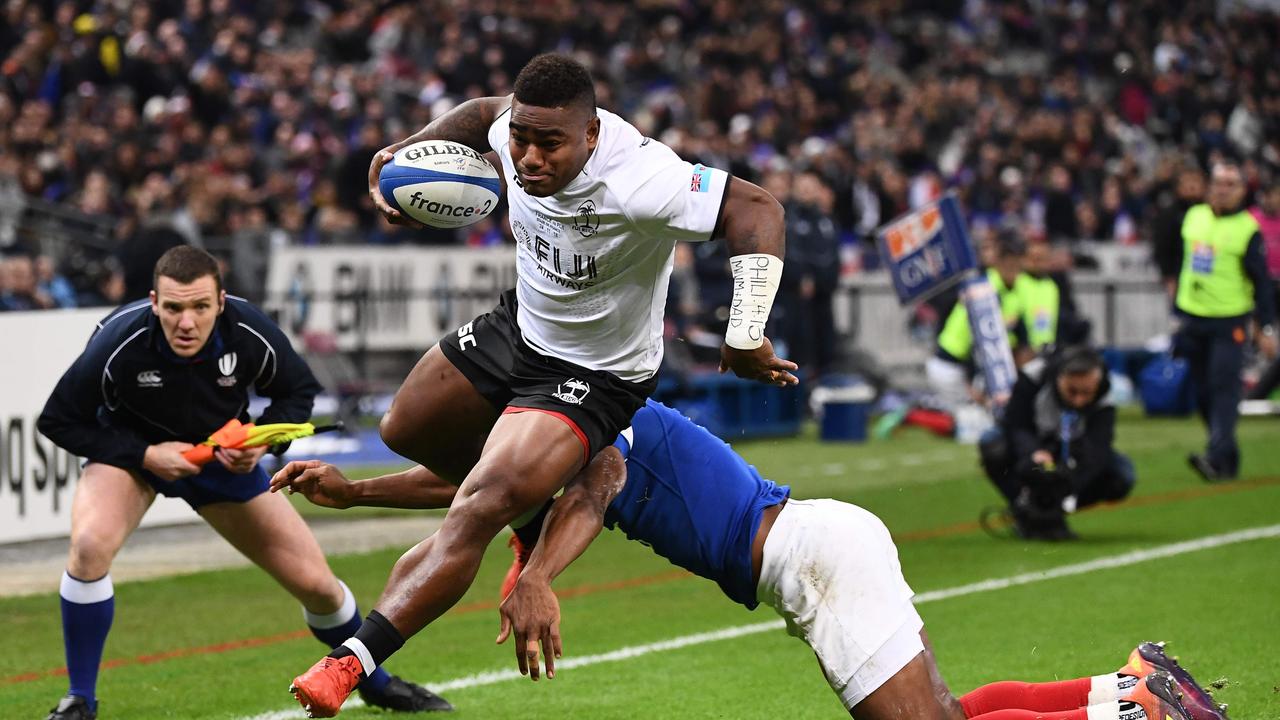 Fiji's Josua Tuisova running to score a try past France's Benjamin Fall