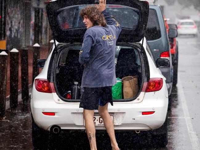 A resident packs a car of stock from a shop in the town of Lismore on March 5, 2025. A rare tropical cyclone veered towards Australia's densely populated eastern coast on March 5, forcing scores of schools to close as worried residents stripped supermarket shelves bare. (Photo by DAVID GRAY / AFP)