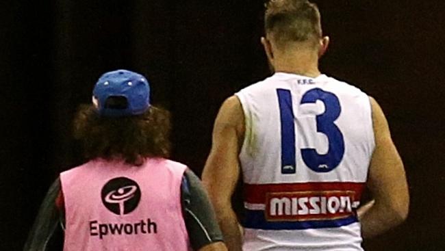 Travis Cloke leaves the ground after the match with doctor. Picture: Wayne Ludbey