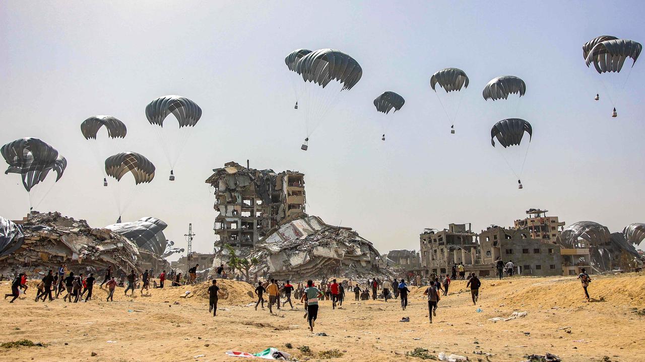 People rush to landing humanitarian aid packages dropped over the northern Gaza Strip. Picture: AFP