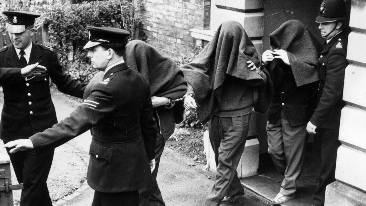 Great Train Robbery’s infamous huge haul would total $100 million by today’s currency. Three handcuffed men arrested in connection with the robbery have blankets draped over their heads as they leave Linslade Court where they were remanded in custody for eight days. Picture: Images Getty