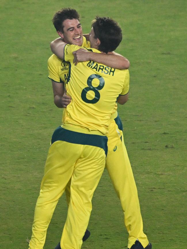 Australia's captain Pat Cummins and Mitchell Marsh (front) celebrate after winning the 2023 ICC Men's Cricket World Cup one-day international (ODI) final match between India and Australia at the Narendra Modi Stadium in Ahmedabad on November 19, 2023. (Photo by Money SHARMA / AFP) / -- IMAGE RESTRICTED TO EDITORIAL USE - STRICTLY NO COMMERCIAL USE --