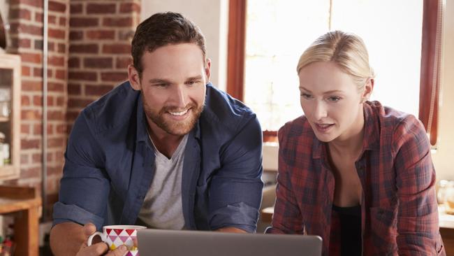 A young couple reviewing their home loan while having a cup of coffee at home. Picture: iStock.