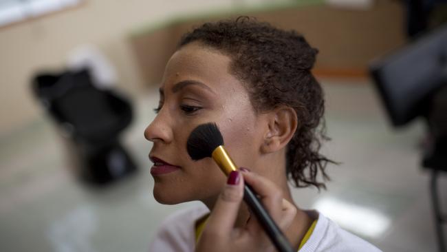 An inmate holds still as an event volunteer applies her blush for the annual beauty contest at Talavera Bruce penitentiary in Rio de Janeiro, Brazil. Picture: AP Photo/Silvia Izquierdo.