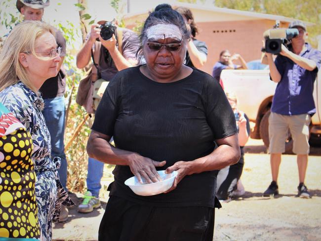 Kumanjayi Walker's mother Leeanne Oldfield paints Coroner Elisabeth Armitage’s forehead during a historic visit to Yuendumu on Monday. Picture: Jason Walls