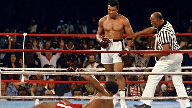 Muhammad Ali looks on after knocking down George Foreman in the eighth round of their championship bout, The Rumble in the Jungle.