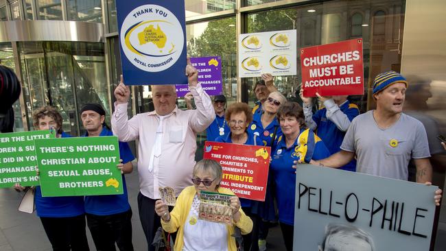 Protesters hold placards outside the County Court in Melbourne. Picture: AP