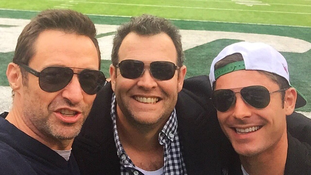 Hugh Jackman with Gus Worland and Zac Efron at the football.