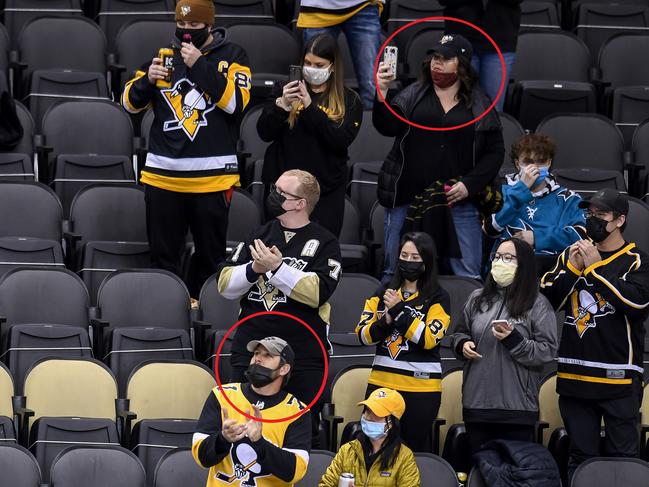 In the original image, masks aren't completely covering the faces of two fans.