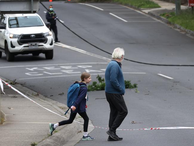 A young student on their way to school on Friday morning. Power cables had been brought down on Main Rd, Eltham. Picture: David Caird