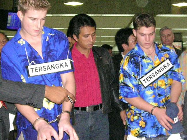 Michael Czugaj (left) and Scott Rush wearing signs meaning ‘suspect’ at a re-enactment of their arrest.