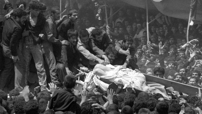 Mourners reach out to the body of Iran's leader Ayatollah Ruhollah Khomeini as his broken coffin is passed overhead during funeral ceremonies for the Islamic fundamentalist in Tehran, June 6, 1989.