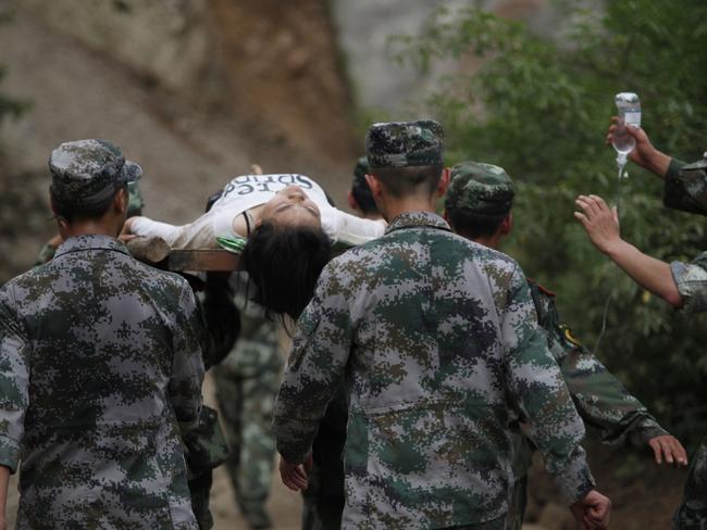 Chinese rescuers carry an injured resident after the earthquake. AFP PHOTO/STR CHINA OUT