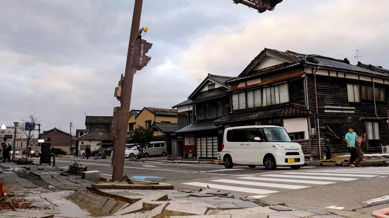 A car drives past a badly damaged pavement along a street in the city of Wajima. Picture: AFP