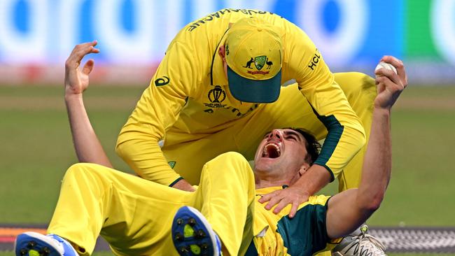 Pat Cummins celebrates with Marnus Labuschagne after taking the catch to dismiss South Africa's Quinton de Kock. (Photo by DIBYANGSHU SARKAR / AFP)