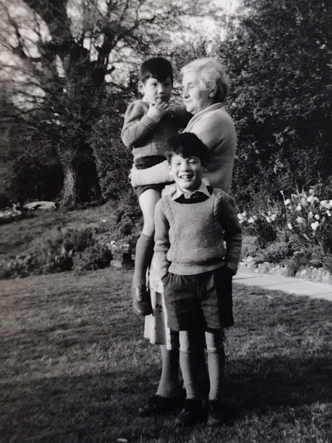 Peter Sandeman standing while adoptive mother Ethel May Sandeman holds John.