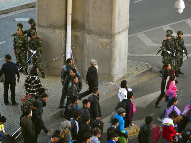Chinese paramilitary policemen stand on duty outside the Urumqi South Railway Station. AP Photo.