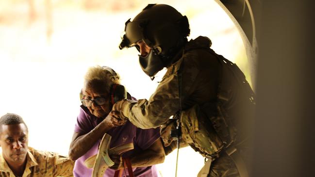 Soldiers help a woman onto a Chinook at Wujal Wujal. Picture: ADF