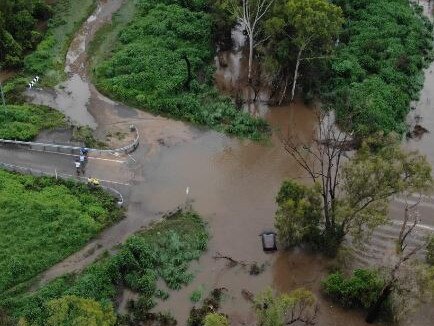 A car is washed off the road at McLeod River Crossing, Mt Carbine. Picture: QFES