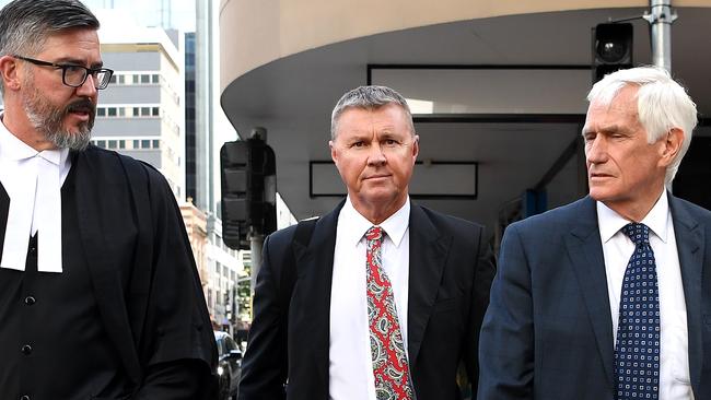 Former union boss Dave Hanna, centre, walks with his legal team as they leave the District Court in Brisbane. Picture: AAP