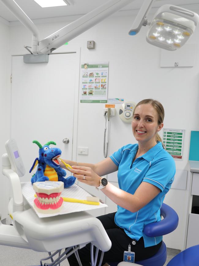 Cairns and Hinterland Health and Hospital Service oral health team leader Stephanie Wallace demonstrates how to brush teeth on a dragon prop, to help children understand the importance of oral hygiene. Photo: Catherine Duffy.