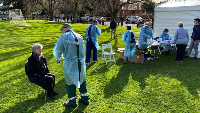 Interstate health workers from Adelaide take swab samples at a COVID-19 testing side in Brunswick, Melbourne. Picture: AFP.