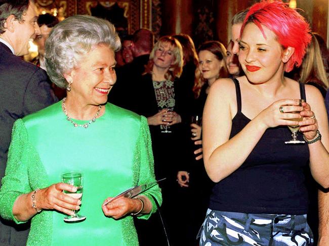 Queen Elizabeth II holding glass of wine with performing arts student Julie Thompson after a rock concert at Buckingham Palace. Picture: Supplied