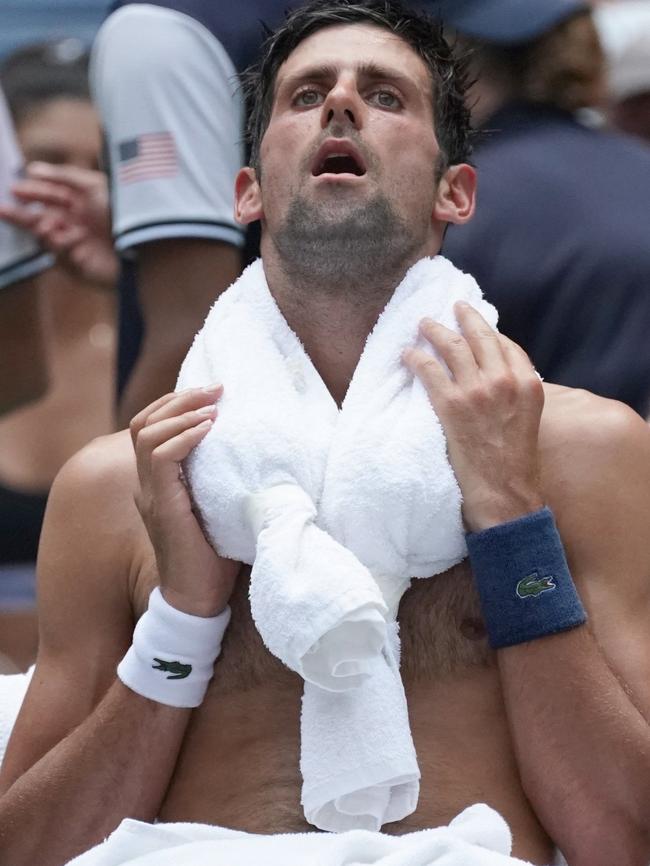 Novak Djokovic takes a break from the heat — without his shirt. Picture: Timothy A. Clary/AFP