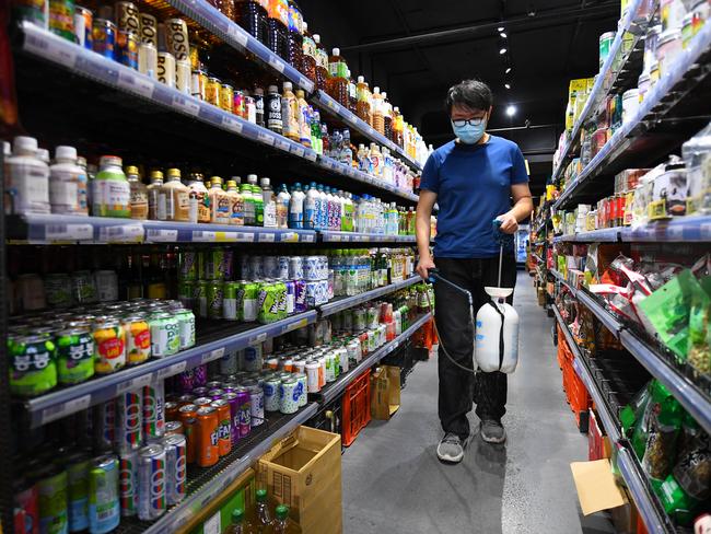 An employee of Great Asia food store sprays disinfectant as a preventive measure against coronavirus in Melbourne. Picture: AAP