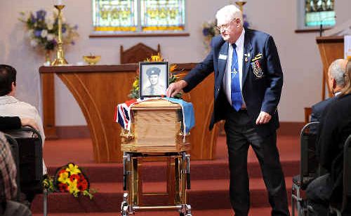 CHAMPION BLOKE: Max Lewis, president of the Ballina RSL Sub-branch, places a red poppy on the coffin of Stan Tilley during yesterday’s funeral service at St Mary’s Anglican Church in Ballina. Picture: Jacklyn Wagner