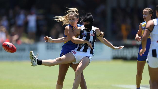 Alison Downie gets a kick away for the Magpies.