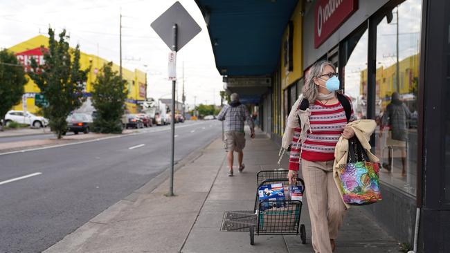 A shopper takes her groceries home on the deserted streets of Preston. Picture: AAP Image/Stefan Postles