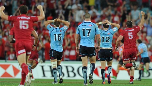 Stunned NSW Waratahs players and fans watch as the Queensland Reds run in to celebrate Do