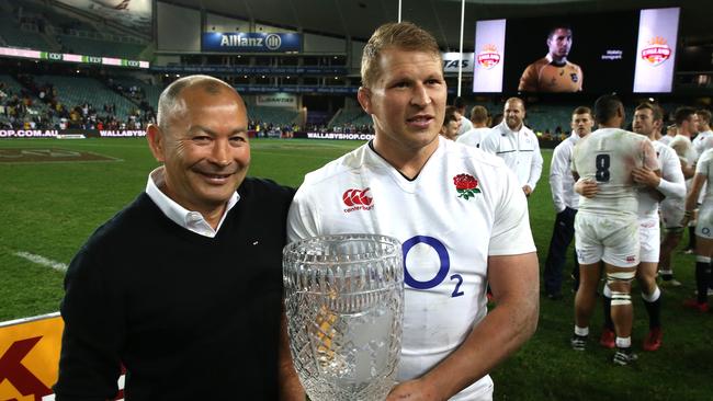Dylan Hartley, the England captain, raises the Cook Cup with coach Eddie Jones.