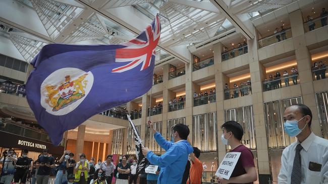 Protesters wave a Hong Kong colonial flag in a shopping mall on Tuesday. Picture: AP