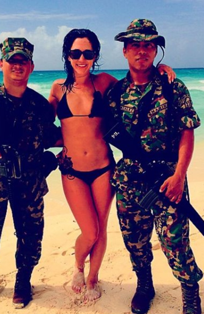 Melina Roberge poses with soldiers at an island cruise ship stop along the way.